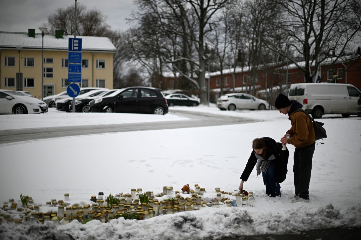 People put candles and flowers at a makeshift memorial in front of the Viertola School in Vantaa, in the north of the Finnish capital Helsinki, on April 3, 2024, one day after a 12-year-old opened fire inside the school, killing a classmate and seriously injuring two other children. Photo by Olivier MORIN / AFP