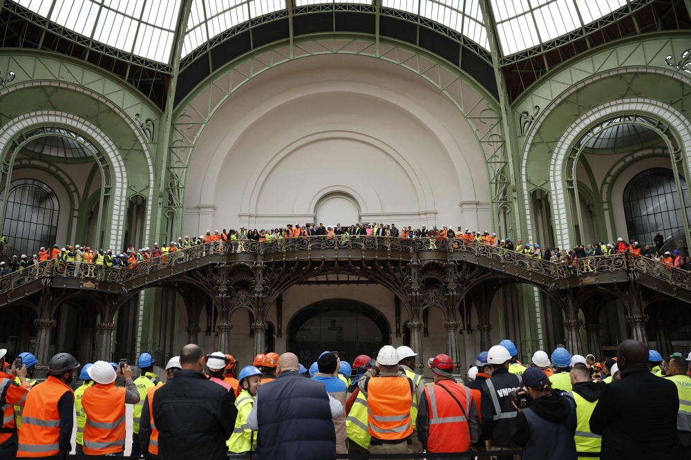 France's President Emmanuel Macron addresses employees in charge of the renovation work during his visit to Le Grand Palais, in Paris, on April 15, 2024, 100 days ahead of the Paris 2024 Olympic Games. Photo by Yoan VALAT / POOL / AFP