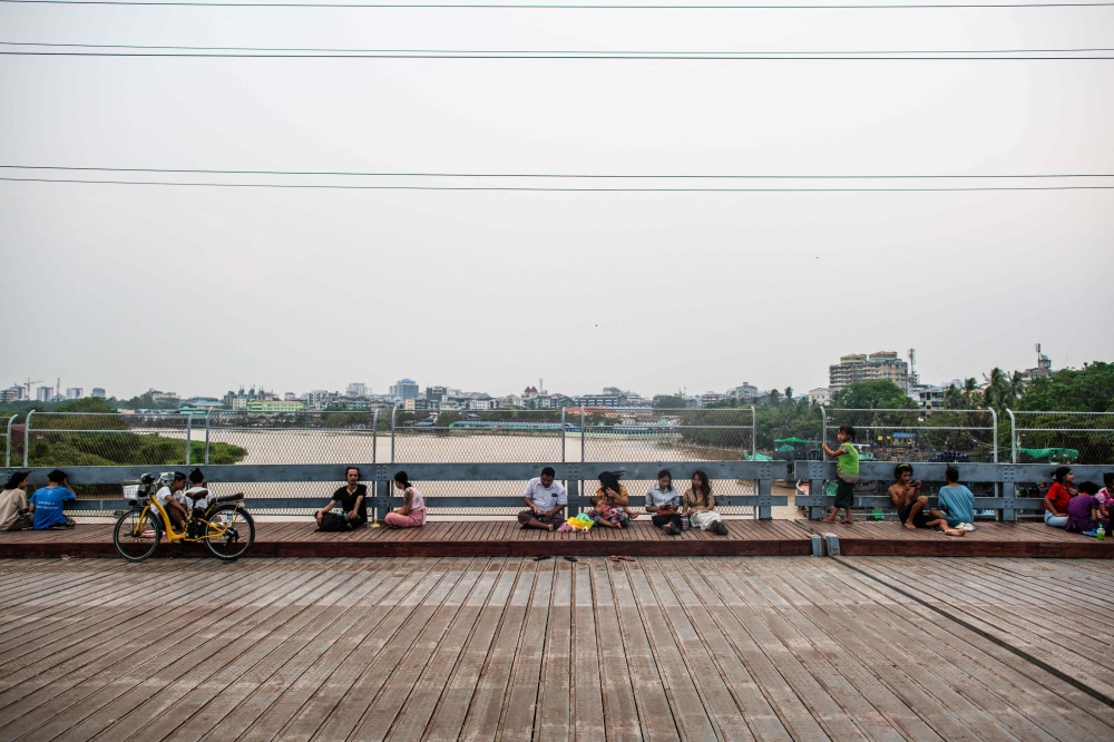 People gather in a park during an electricity blackout in Yangon on April 26, 2024. (Photo by Sai Aung Main / AFP)