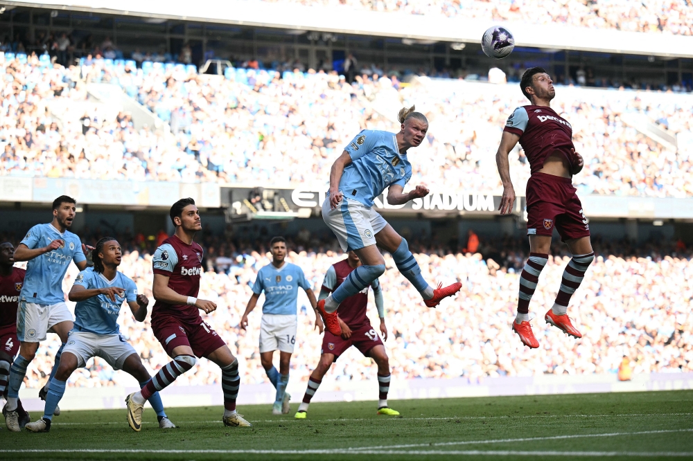 Manchester City's Norwegian striker #09 Erling Haaland (2R) jumps for a corner kick during the English Premier League football match between Manchester City and West Ham United at the Etihad Stadium in Manchester, north west England, on May 19, 2024. (Photo by Oli SCARFF / AFP) 