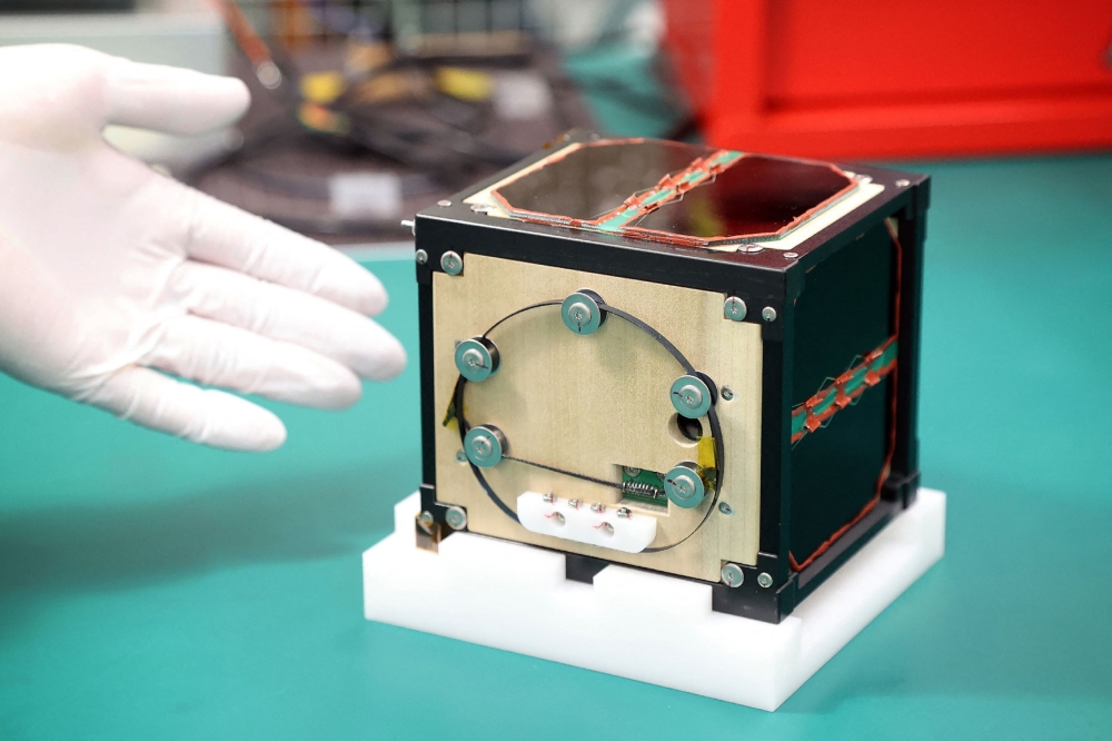 The world's first wooden satellite made from wood and named LignoSat, developed by scientists at Kyoto University and logging company Sumitomo Forestry, is shown during a press conference at Kyoto University in Kyoto on May 28, 2024. (Photo by JIJI Press / AFP) 