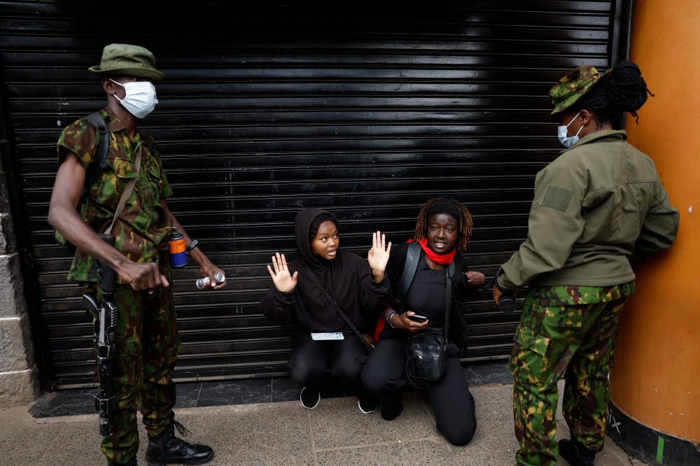 Kenyan activists react after they were detained by Kenya police officers during a demonstration against overtaxation in Nairobi on June 18, 2024. (Photo by Simon Maina / AFP)