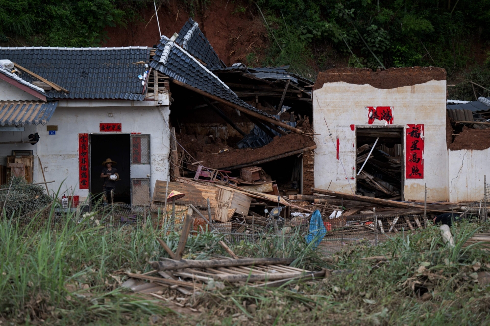 A villager walks out from a damaged building in the aftermath of flooding in Meizhou, in southern China's Guangdong province on June 21, 2024. (Photo by AFP) / China OUT
