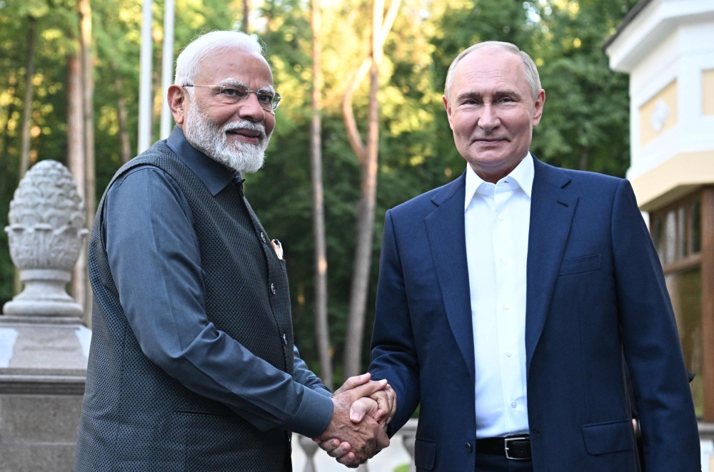 In this pool photograph distributed by the Russian state agency Sputnik, Russia's President Vladimir Putin welcomes Indian Prime Minister Narendra Modi for an informal meeting at the Novo-Ogaryovo state residence, outside Moscow, on July 8, 2024. (Photo by Sergei BOBYLYOV / POOL / AFP)