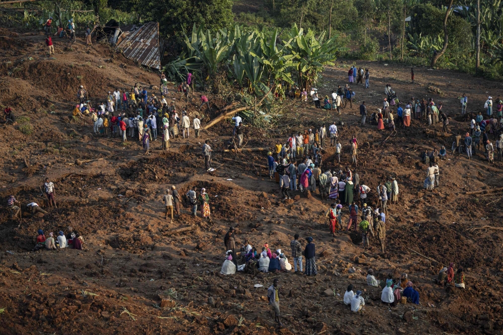 Residents and volunteers dig in the mud in search for survivors and bodies at the scene of a landslide in Gofa on July 24, 2024. (Photo by Michele Spatari / AFP)
