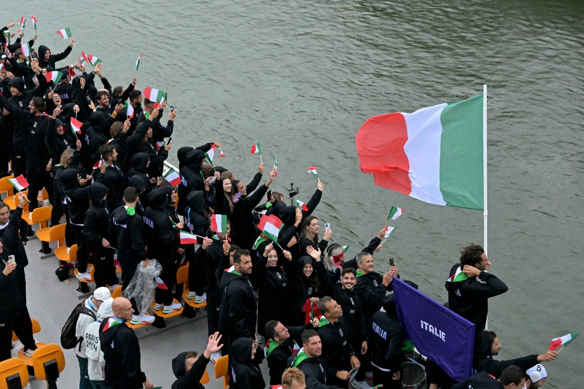 Italy's delegation with Italy's flag bearer Gianmarco Tamberi (R) sails on a boat during the opening ceremony of the Paris 2024 Olympic Games in Paris on July 26, 2024. (Photo by Damien MEYER / AFP)