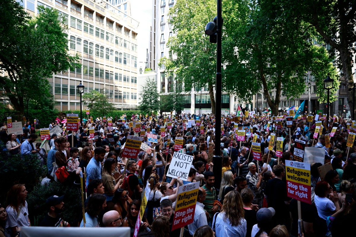 People hold anti-racist placards as they take part in a 
