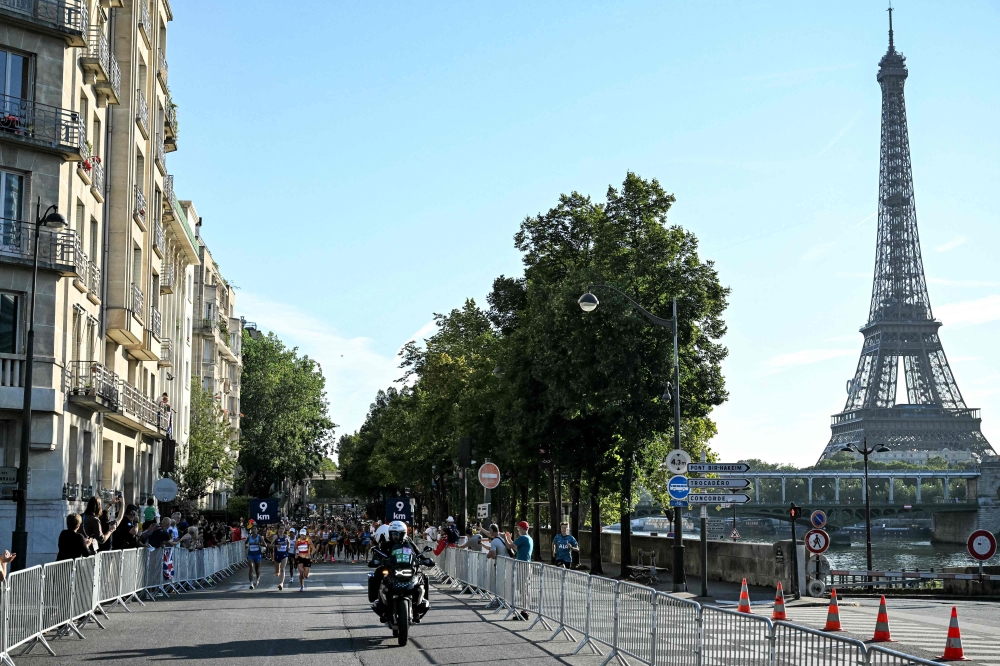 Athletes run past Eiffel Tower, as they compete in the women's marathon of the athletics event at the Paris 2024 Olympic Games in Paris on August 11, 2024. (Photo by Kirill KUDRYAVTSEV / AFP)
