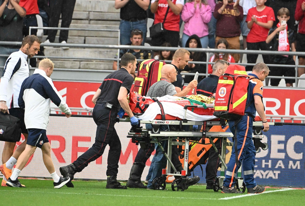 Lille's English forward Angel Gomes is evacuated on a stretcher off the pitch after being injured during the French L1 football match between Stade de Reims and Lille LOSC at the Stade Auguste-Delaune in Reims, northern France, on August 17, 2024. (Photo by FRANCOIS NASCIMBENI / AFP)

