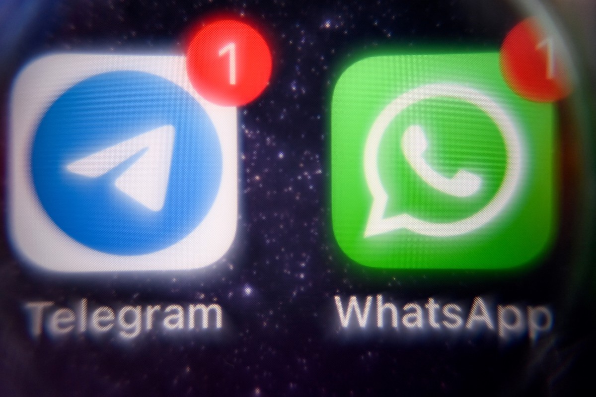 This picture taken on March 23, 2022 shows the mobile messaging and call service Telegram logo and US instant messaging software Whatsapp logo on a smartphone screen in Moscow. Photo by AFP.