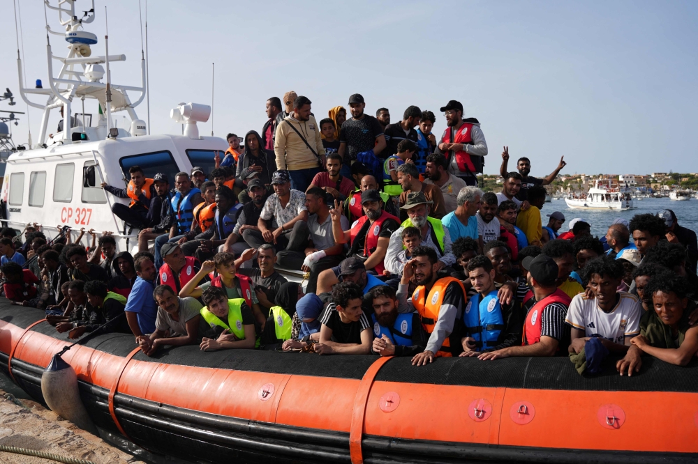 Migrants arrive in the harbour of Italian island of Lampedusa, on September 18, 2023. (Photo by Zakaria ABDELKAFI / AFP)