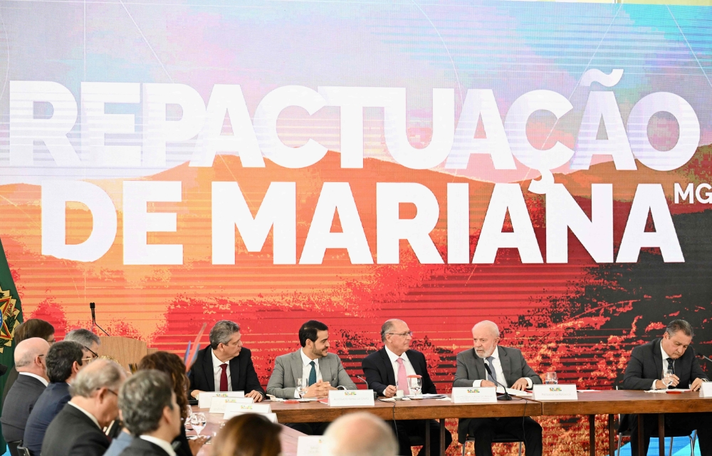 Brazilian President Luiz Inacio Lula da Silva (2nd right) attends the signing of a new agreement to repair the damage caused by the Fundao dam collapse tragedy in Mariana, Minas Gerais State, at a ceremony at the Planalto Palace in Brasilia, on October 25, 2024. (Photo by Evaristo Sa / AFP)
