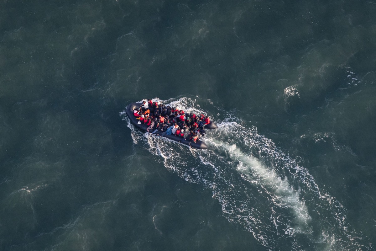 (FILES) This aerial picture taken on September 16, 2023, from a police aircraft belonging to the French Police Aux Frontieres (PAF) shows migrants onboard of a dinghy used for smuggling as they attempt to cross the English Channel to Britain from a beach at Le Touquet, northern France. (Photo by Sameer Al-DOUMY / AFP)
