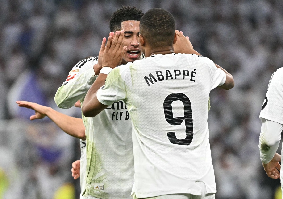 Real Madrid's French forward #09 Kylian Mbappe celebrates with teammates scoring his team's second goal during the Spanish league football match between Real Madrid CF and Getafe CF at the Santiago Bernabeu stadium in Madrid on December 1, 2024. (Photo by JAVIER SORIANO / AFP)
