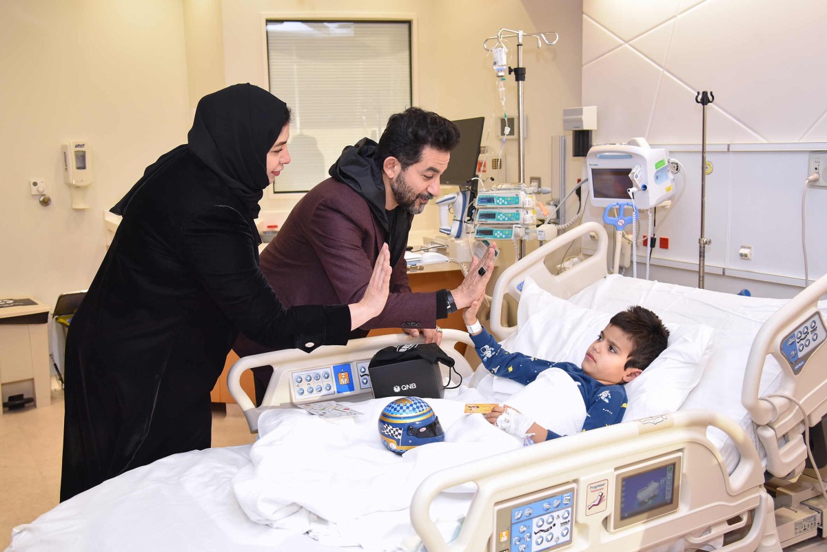 QNB officials with a young patient during the visit.