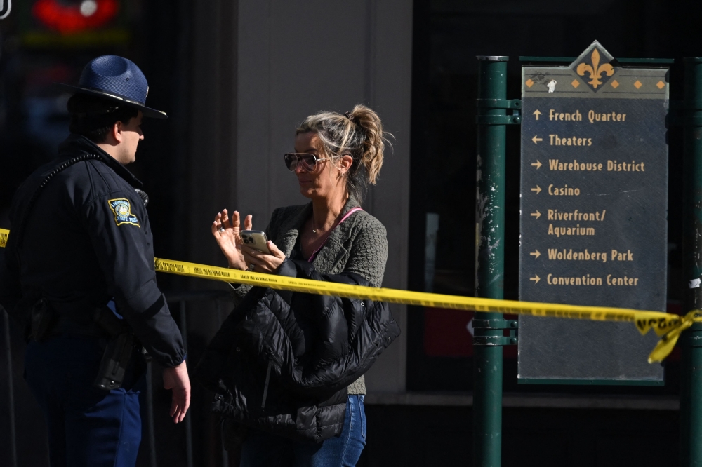 A woman speaks with a police officer near a blocked off street in the French Quarter on January 2, 2025 in New Orleans, Louisiana. (Photo by Andrew Caballero-Reynolds / AFP)