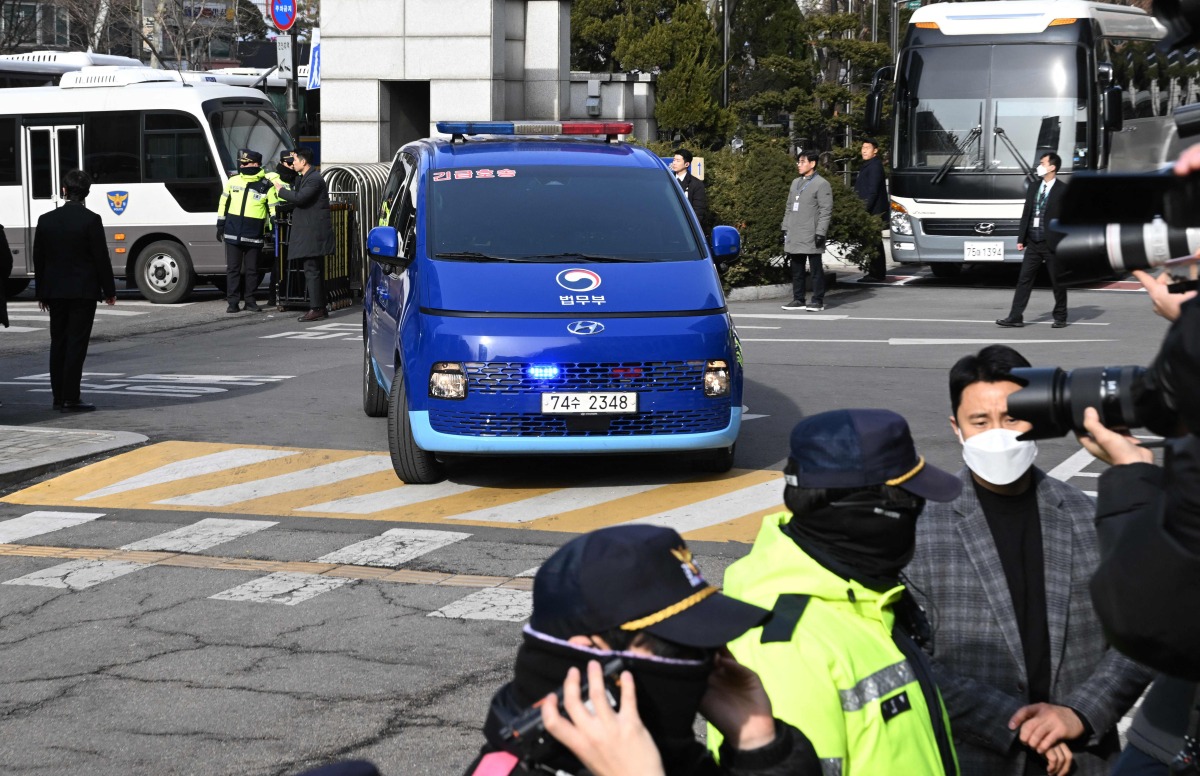A blue van believed to be transporting impeached South Korea President Yoon Suk Yeol arrives at the Seoul Western District Court in Seoul on January 18, 2025, for a hearing which will decide whether to extend Yoon's detention as investigators probe his failed martial law bid. (Photo by JUNG YEON-JE / POOL / AFP)
