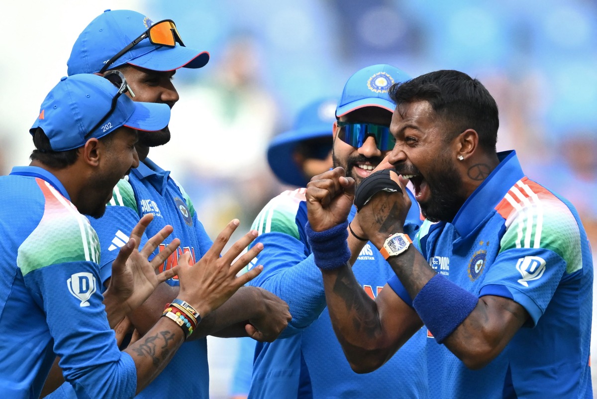 India's Hardik Pandya (R) celebrates with teammates after taking the wicket of Pakistan's Saud Shakeel during the ICC Champions Trophy one-day international (ODI) cricket match between Pakistan and India at the Dubai International Stadium in Dubai on February 23, 2025. (Photo by Jewel SAMAD / AFP)
