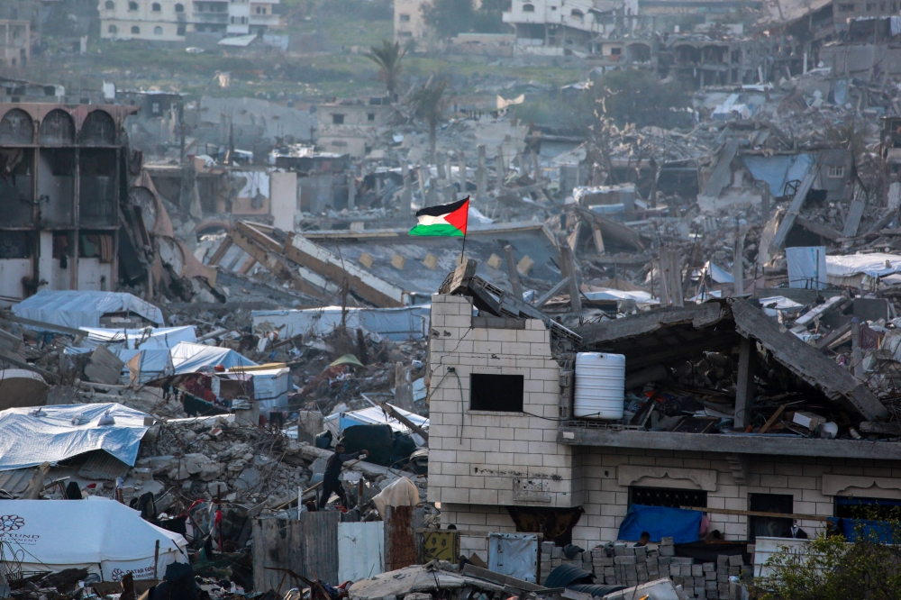 A Palestinian flag flutters amid the ruins of buildings in Beit Lahia in the northern Gaza Strip on March 4, 2025. (Photo by Bashar Taleb / AFP)