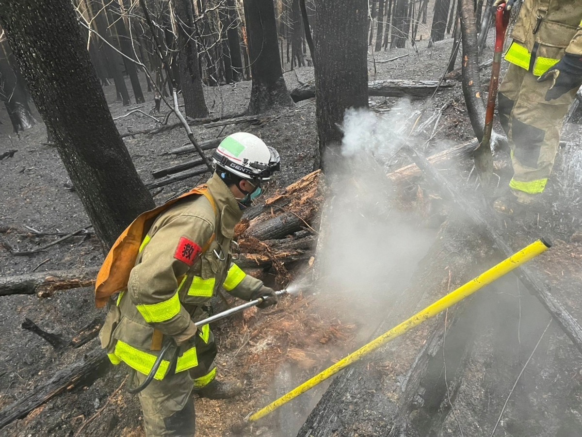 This photo taken on March 5, 2025 and released on March 6 by Japan's Fire and Disaster Management Agency shows firefighters battling a wildfire in Ofunato city of Iwate Prefecture. Photo by Handout / Fire and Disaster Management Agency / AFP