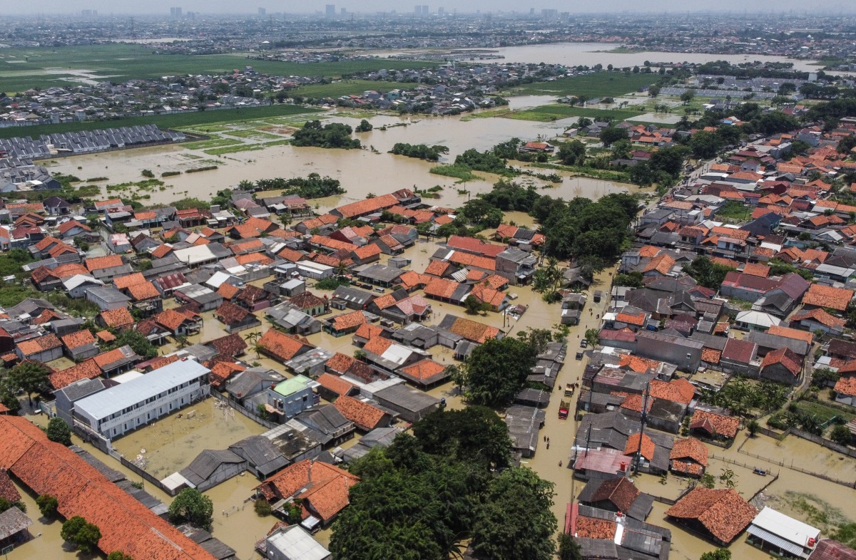 An aerial picture shows a flooded residential area after some rivers overflowed following heavy rain in Bekasi, a suburb of Jakarta, on March 5, 2025. (Photo by Aditya Irawan / AFP)
