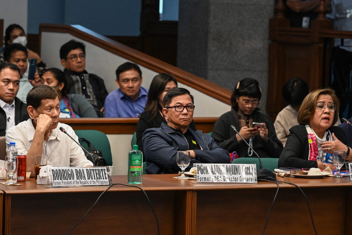 (L-R) Former Philippine president Rodrigo Duterte, former Philippine Drug Enforcement Agency director general Aaron Aquino, and former senator and human rights campaigner Leila de Lima attend a senate probe on the drug war during Duterte's administration, in Manila on October 28, 2024. Photo by Jam STA ROSA / AFP