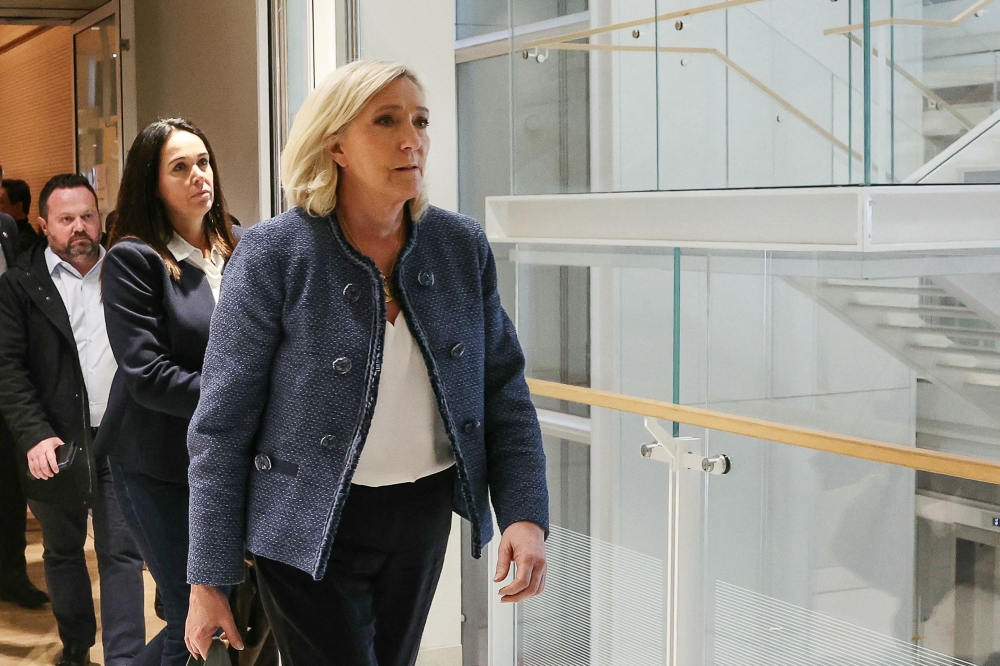 President of the parliamentary group of the French far-right Rassemblement National (RN) party, Marine Le Pen (R), walks followed by co-defendant French member of European Parliament Catherine Griset (L) as they exit a courtroom in Paris, on March 31, 2025. (Photo by Alain Jocard / AFP)