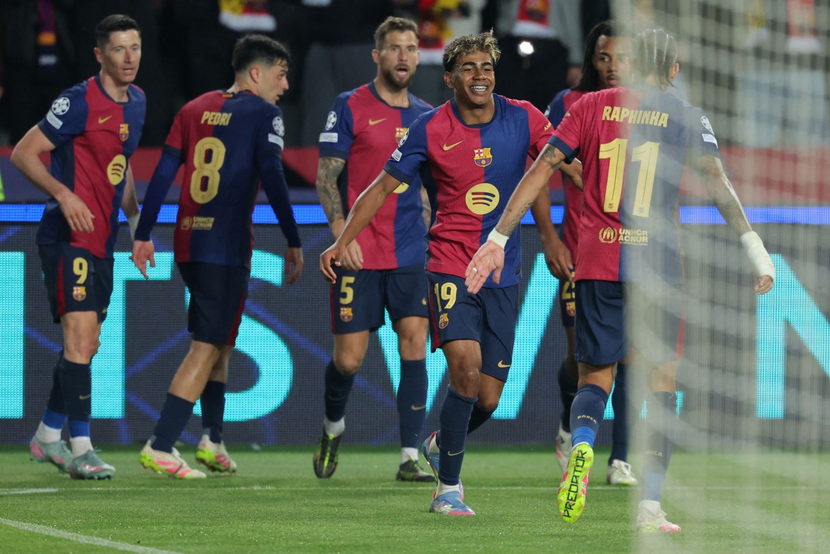 Barcelona's Spanish forward #19 Lamine Yamal and teammates celebrate Barcelona's Polish forward #09 Robert Lewandowski's third goal during the UEFA Champions League Quarter final First Leg football match between FC Barcelona and BVB Borussia Dortmund at the Estadi Olimpic Lluis Companys in Barcelona on April 9, 2025. (Photo by LLUIS GENE / AFP)
