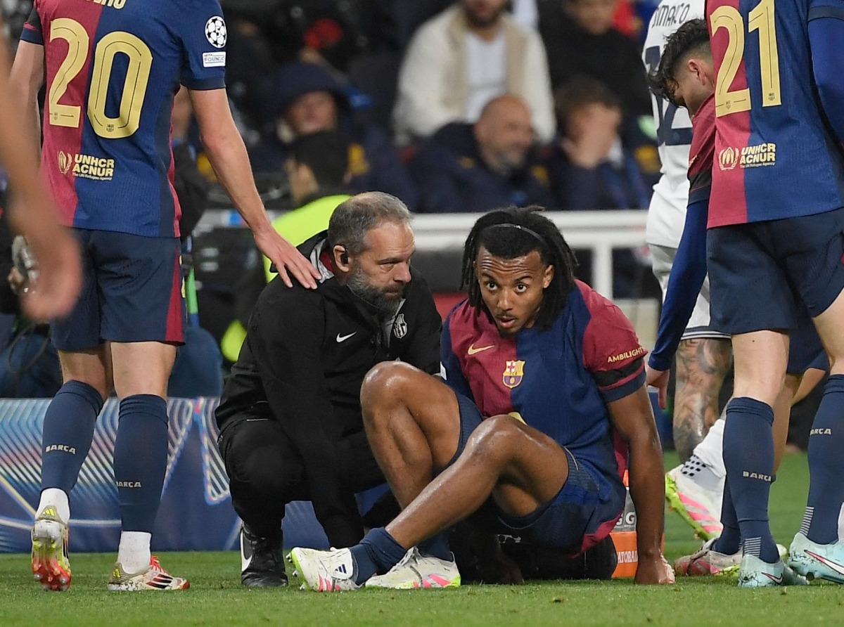 Medical staff's member tends to Barcelona's French defender #23 Jules Kounde during the UEFA Champions League semi final first leg football match between FC Barcelona and Inter Milan at the Estadi Olimpic Lluis Companys in Barcelona on April 30, 2025. (Photo by Josep LAGO / AFP)