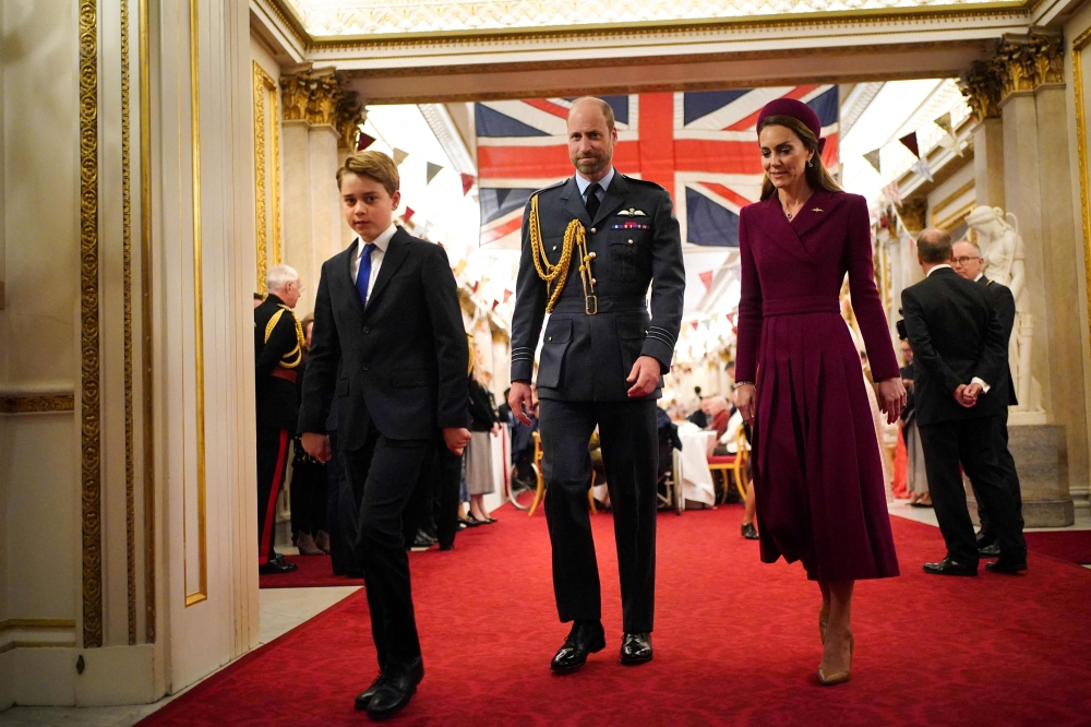 (From left) Britain's Prince George of Wales, Britain's Prince William, Prince of Wales and Britain's Catherine, Princess of Wales arrive for a tea party organised for Second World War veterans at Buckingham Palace on May 5, 2025. (Photo by Yui Mok / POOL / AFP)