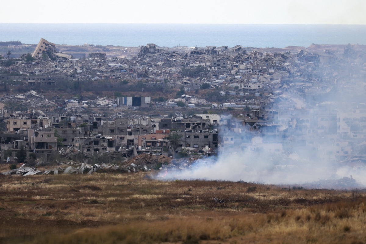 This picture taken from Israel's southern border with the Gaza Strip shows buring fields in front of destroyed houses in northern Gaza on May 4, 2025. Photo by Menahem KAHANA / AFP.