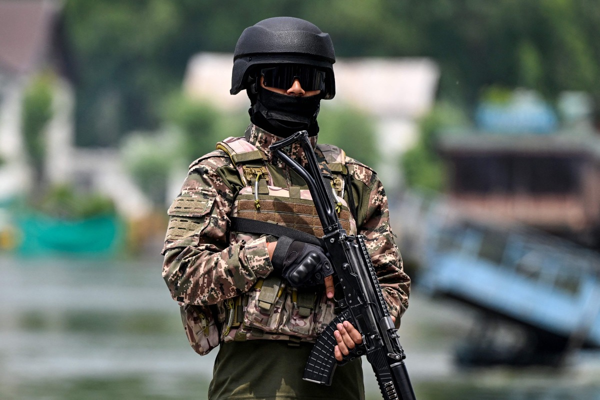 An Indian paramilitary personnel stands guard along the banks of Dal Lake in Srinagar on May 6, 2025. (Photo by Sajjad HUSSAIN / AFP)
