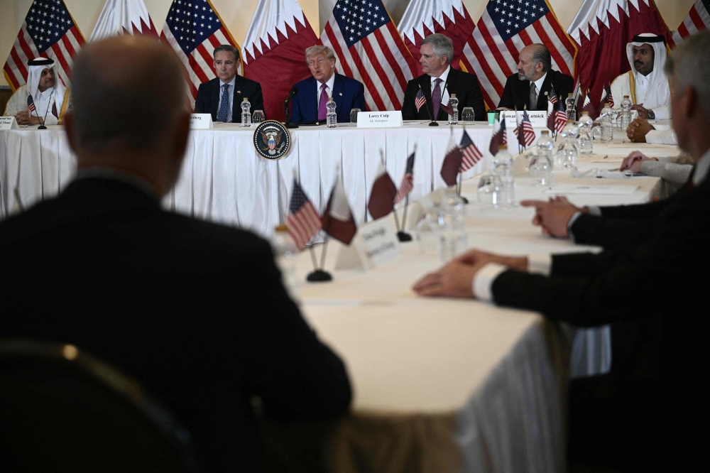 US President Donald Trump (C) attends a breakfast with business leaders in Doha on May 15, 2025. (Photo by Brendan Smialowski / AFP)