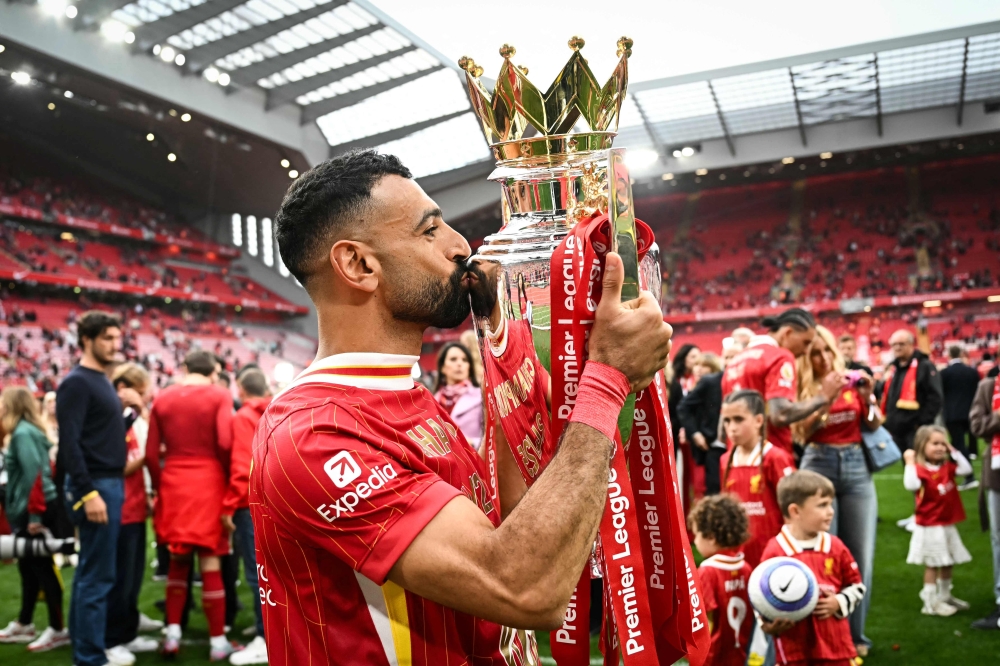 Liverpool's Egyptian striker #11 Mohamed Salah celebrates as he kisses the Premier League trophy at the end of the English Premier League football match between Liverpool and Crystal Palace at Anfield in Liverpool, north west England on May 25, 2025. (Photo by Paul Ellis / AFP)
