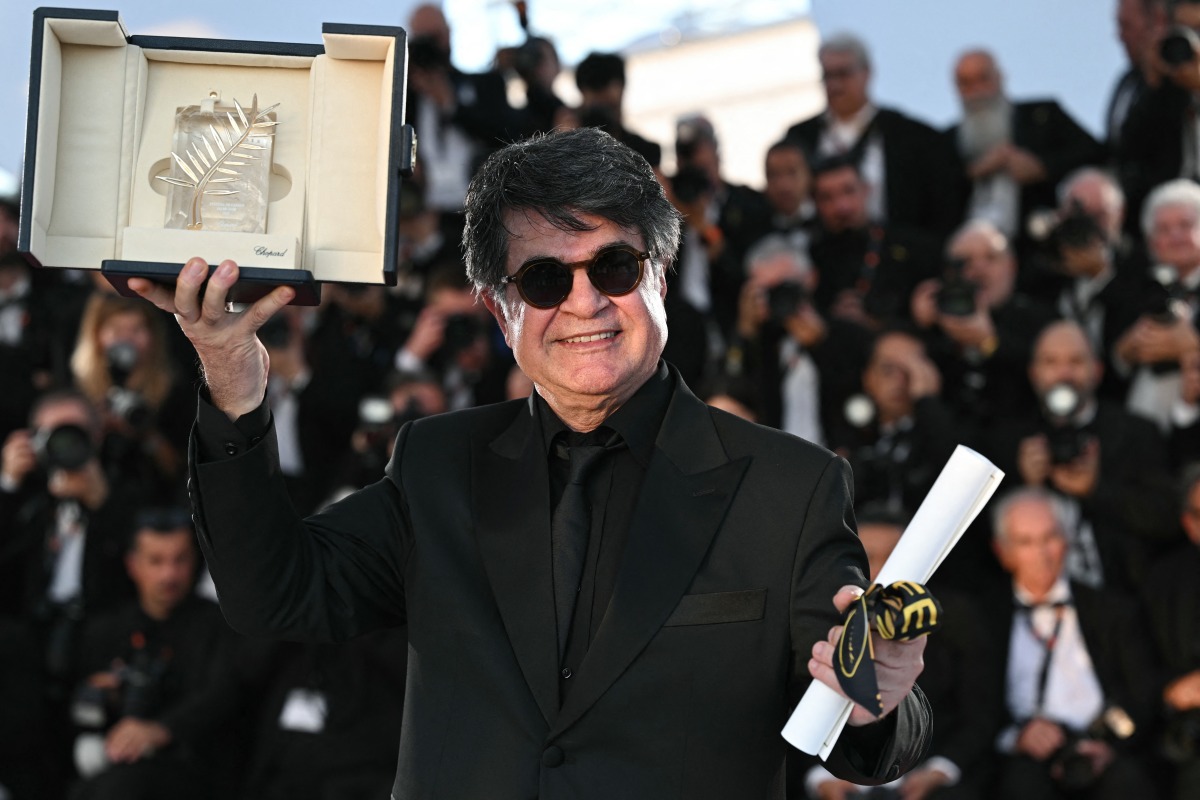Iranian director and screenwriter and producer Jafar Panahi poses with the trophy during a photocall after winning the Palme d'Or for the film 