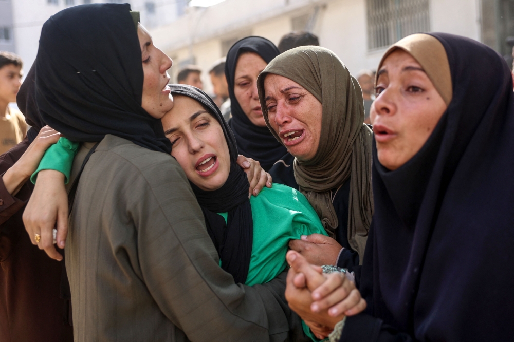 Women mourn relatives killed in an Israeli strike, at Al-Shifa hospital in Gaza City on May 26, 2025. (Photo by Omar Al-Qattaa / AFP)
