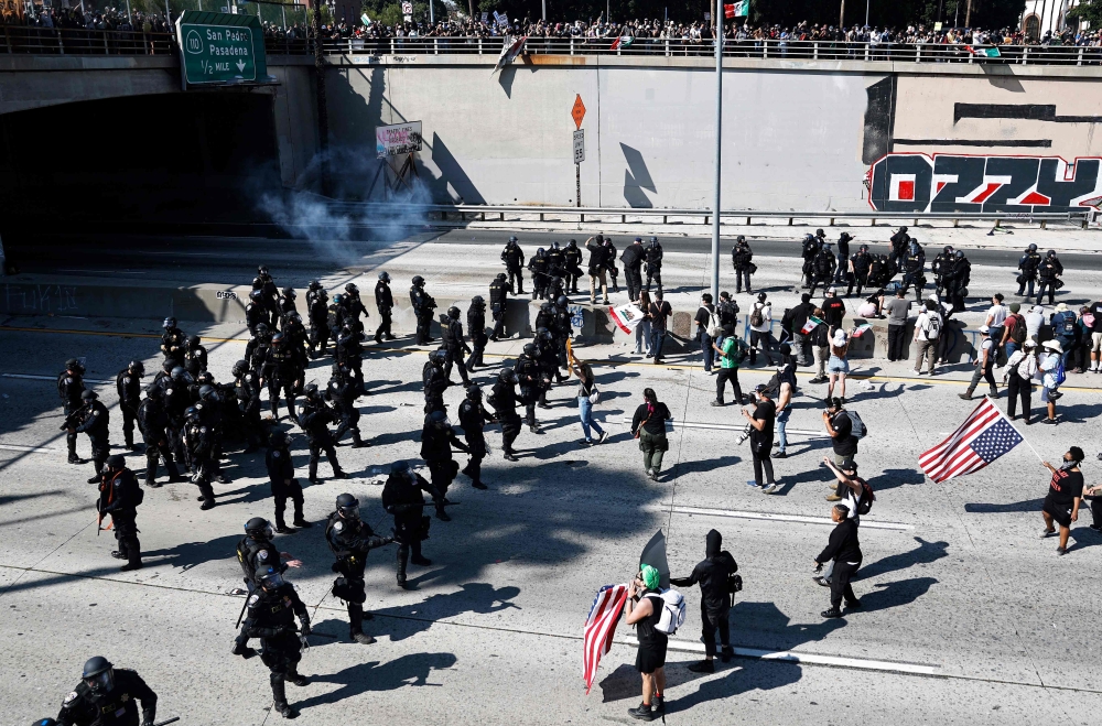 California Highway Patrol (CHP) officers clear protesters blocking the 101 freeway on June 08, 2025 in Los Angeles, California. (Photo by Mario Tama / Getty Images via AFP)
