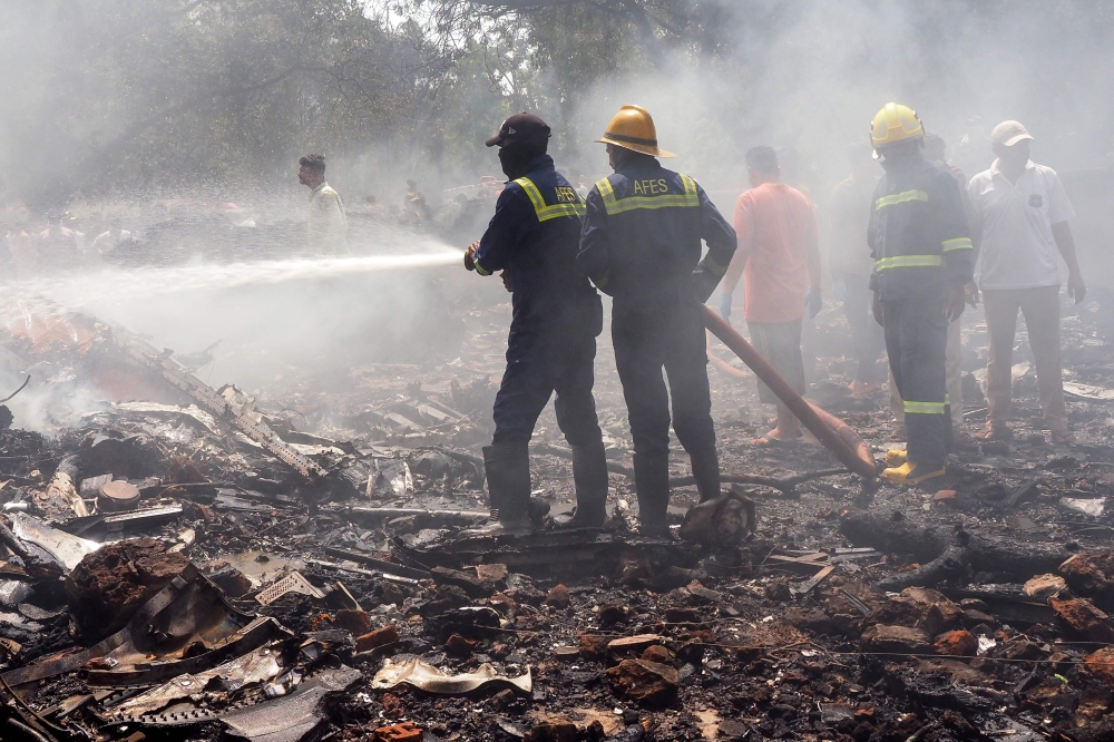 Firefighters working at the scene of the Air India flight crash. AFP file photo.