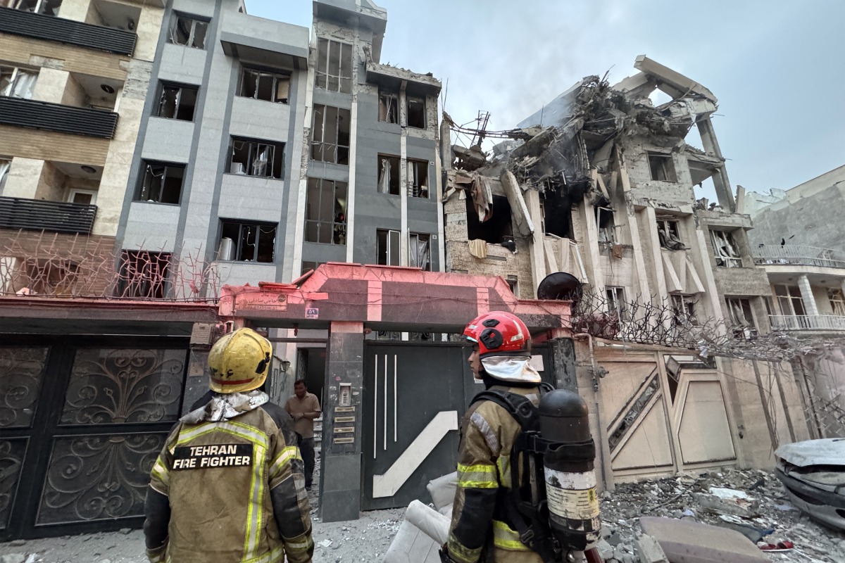 First-responders gather outside a building that was hit by an Israeli strike in Tehran on June 13, 2025. Photo by MEGHDAD MADADI / TASNIM NEWS / AFP.
