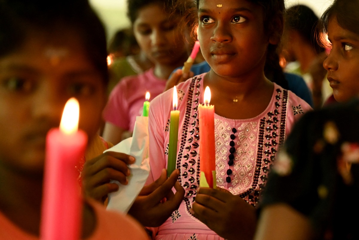 Children hold candles as they pray for the deceased killed in the June 12 Air India flight 171 crash in Ahmedabad, at an orphanage in Chennai on June 14, 2025. Photo by R.Satish BABU / AFP.
