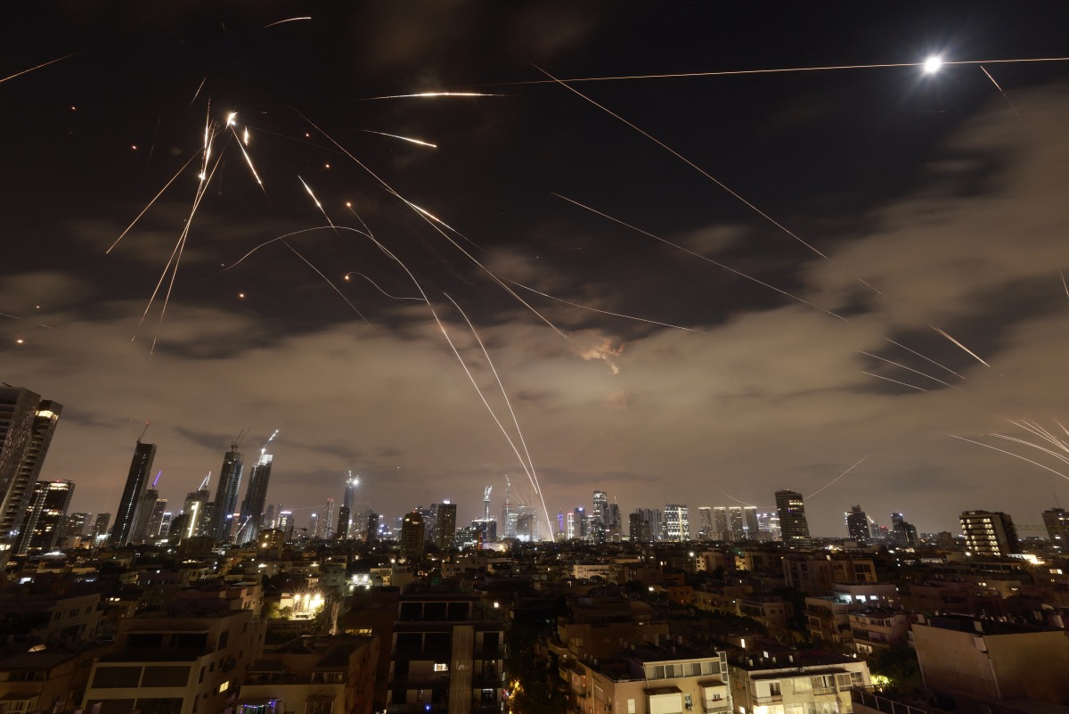 Israeli air defence systems are activated to intercept Iranian missiles over Tel Aviv on June 16, 2025. Photo by Menahem Kahana / AFP.