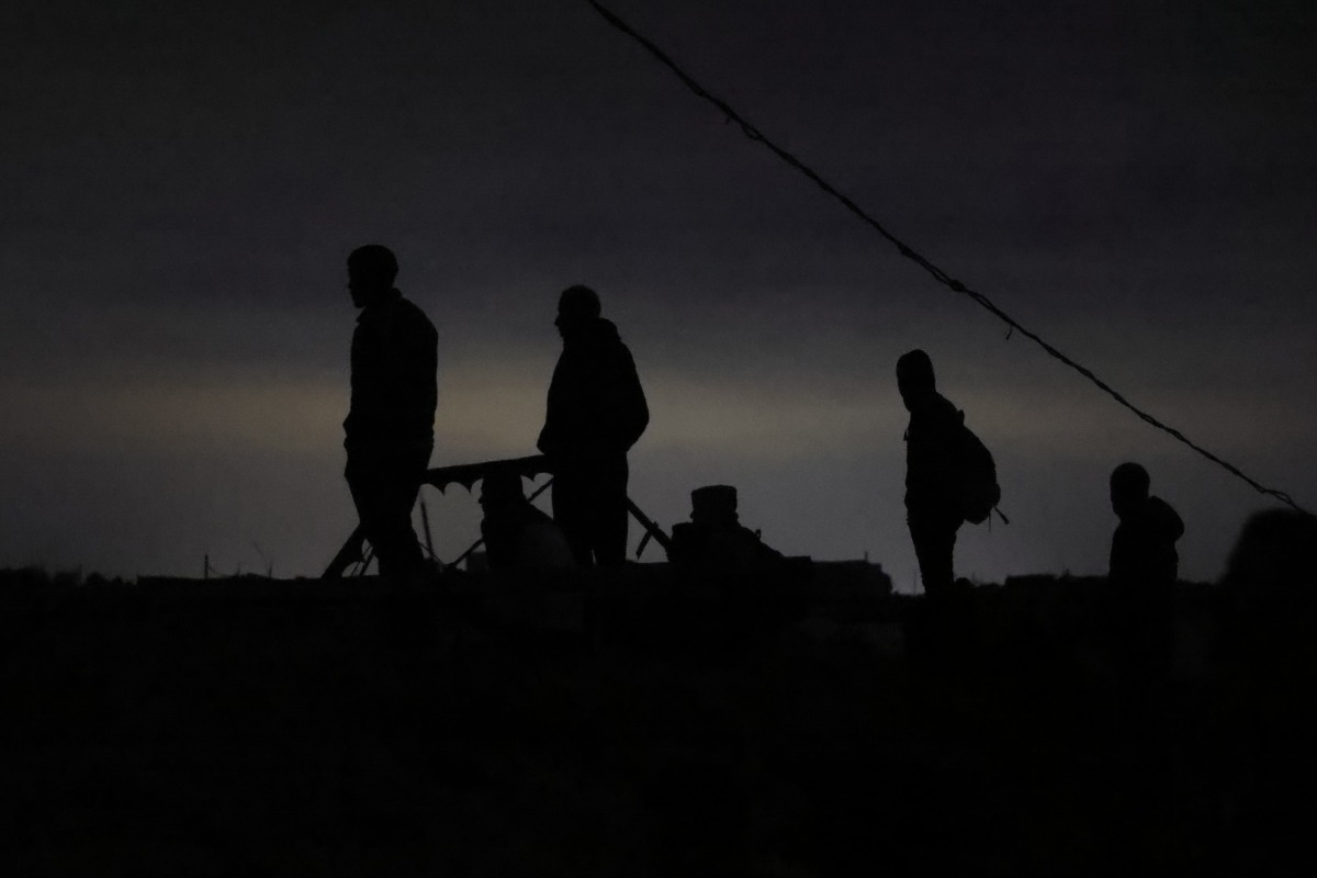 Palestinians gather in wait for the arrival of trucks carrying humanitarian aid near Jabalia, in the northern Gaza Strip late on June 15, 2025. Photo by BASHAR TALEB / AFP.