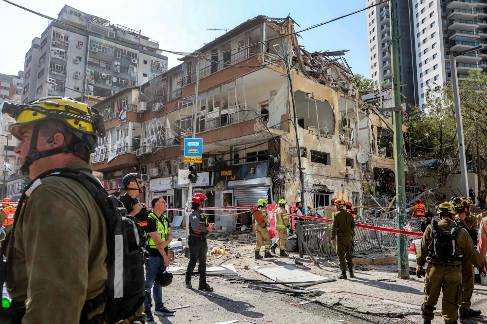 First responders walk outside a heavily-damaged building at the site of an Iranian missile attack in Ramat Gan in central Israel near Tel Aviv, on June 19, 2025. (Photo by GIL COHEN-MAGEN / AFP)