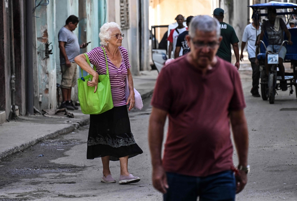 Elderly people walk in a street of Havana, on June 3, 2025. (Photo by Yamil Lage / AFP)