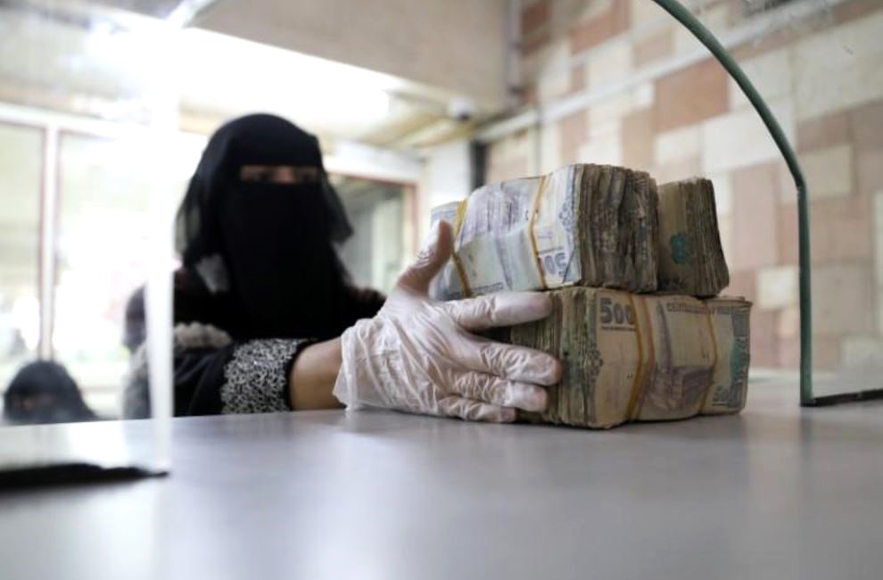 An employee takes bundles of Yemeni riyals / Reuters file photo