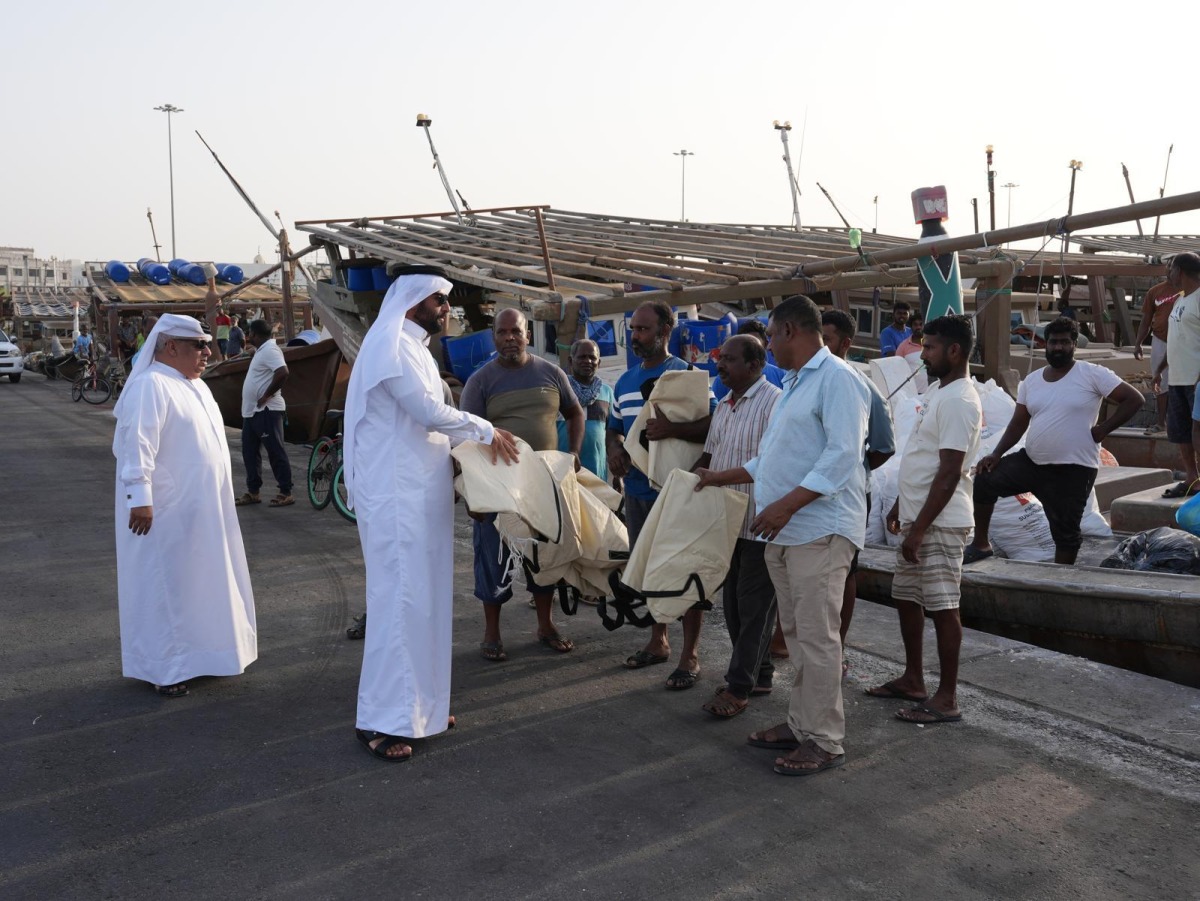 MECC officials distributing eco-friendly bags to fishermen during an awareness campaign to curb the use of plastic bags. 
