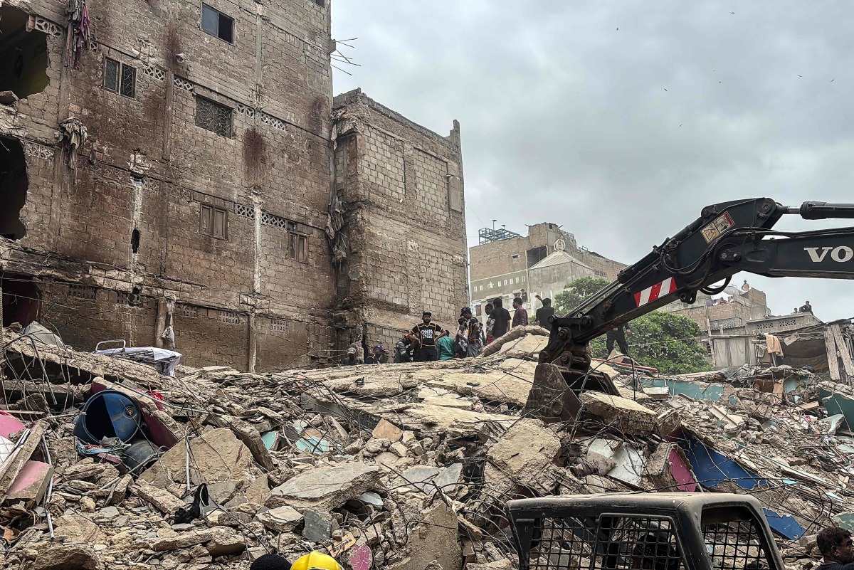 Rescuers search for victims in the rubble of a collapsed five-storey residential building in Karachi on July 4, 2025. (Photo by Rizwan TABASSUM / AFP)