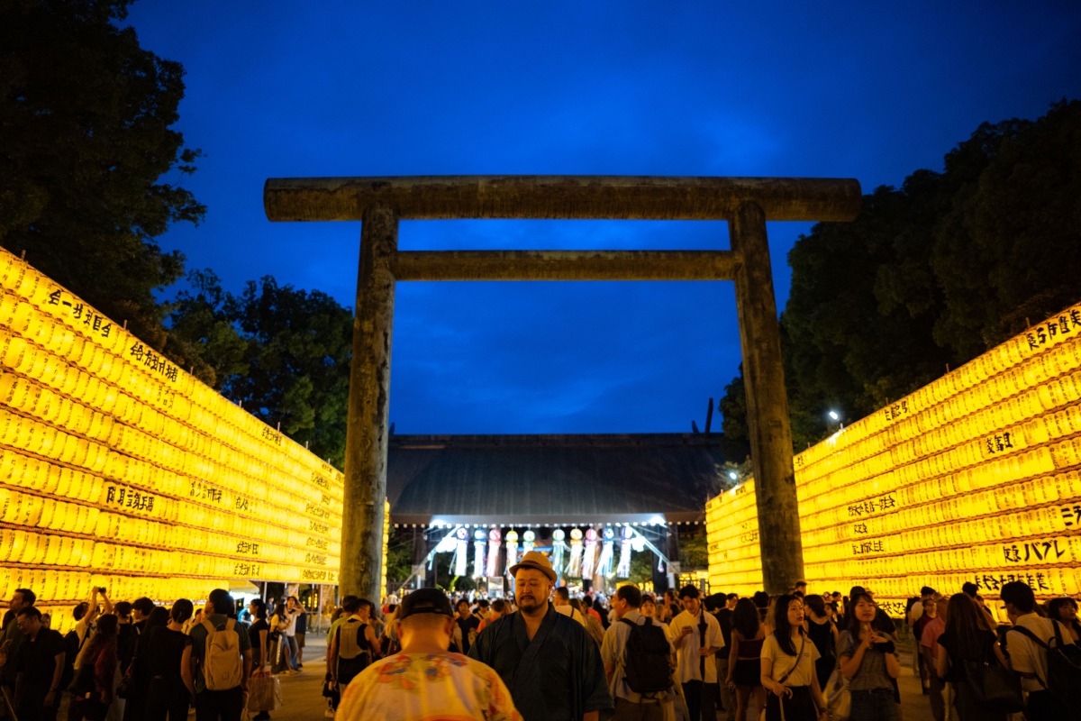 People gather in front of thousands of lanterns on display on the last day of the Mitama Matsuri, one of the capital's largest summer 