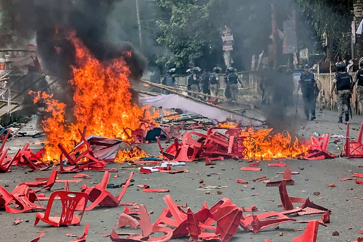 Anti-riot police personnel patrol along a street ravaged with burning plastic chairs, allegedly vandalised by the Awami League party activists rebuking a rally by the newly formed Jatiya Nagarik Party, or National Citizen's Party in Gopalganj on July 16, 2025. (Photo by AFP)
