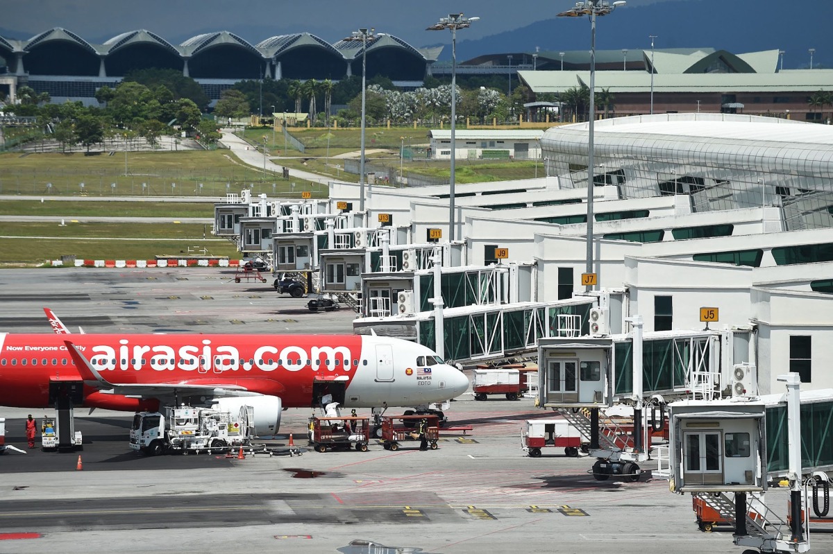 An Air Asia Airbus A320 aircraft is seen on the tarmac at the Kuala Lumpur International Airport's low-cost carrier terminal in Sepang on March 8, 2022. (Photo by Arif Kartono / AFP)
